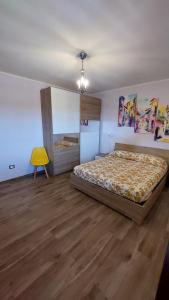 a bedroom with two beds and a yellow chair at Casa Zia Maria 6 posti Monterosso Coast to Coast in Monterosso +4 photos