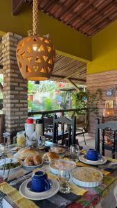 un tavolo con sopra piatti di cibo di POUSADA DONNA MARIA a São Miguel do Gostoso