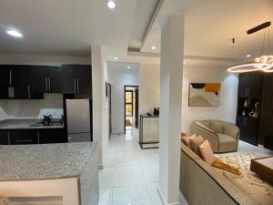 a kitchen and living room with a couch and a table at Aj3 LUXURY HOME in Yaoundé