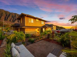 a wooden house with a patio in front of it at Kalo Homes - House of Aloha in Makaha Valley