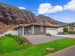 a house with a mountain in the background at Kalo Homes - Surfside Serenity in Makaha Valley