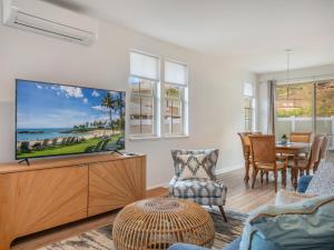 a living room with a large flat screen tv at Kalo Homes - Surfside Serenity in Makaha Valley