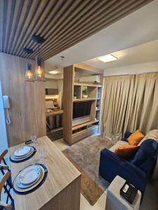 a living room with a couch and a table at Travellar Apt 91 - Admirável - Monte Carmelo in Ribeirão Preto