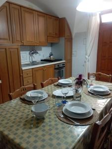 a kitchen with a table with plates and glasses on it at Casa Checco in Cisternino +5 photos