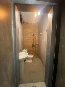a bathroom with a white toilet and a sink at Maison Rose Ngaparou in Ngaparou