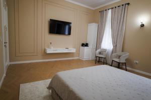 a bedroom with a bed and a tv on the wall at Citadelle house in Alba Iulia