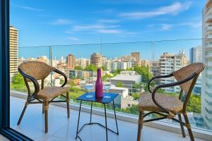 due sedie e un tavolo con un vaso su una finestra di Upscale City Center Condo a Carlos Guerra