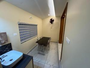 a bathroom with a sink and a table and a window at Kurinjirappallil Farms Homestay in Paithalmala