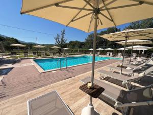 a pool with chairs and umbrellas and a swimming pool at La Noce di Creta in Poggio Moiano