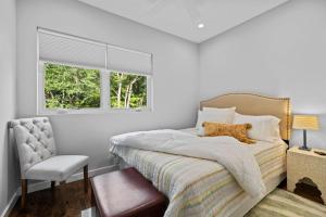 a bedroom with a bed and a chair and a window at On Cloud Durham Unit B in Durham