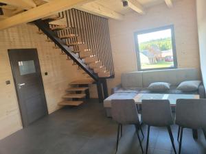 a room with a couch and a table and a staircase at Jodłowy domek na Roztoczu in Obrocz