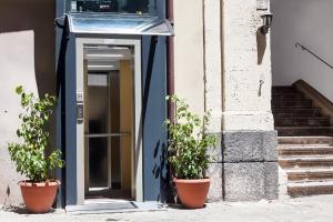 a blue door with two potted plants in front of a building at BMode in Catania +15 photos
