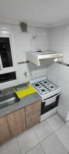 a small kitchen with a stove and a sink at Departamento Temporario Tucuman 3Personas Pileta in San Miguel de Tucumán +4 photos