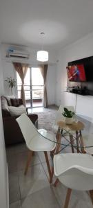 a living room with white chairs and a couch at Departamento Temporario Tucuman 3Personas Pileta in San Miguel de Tucumán