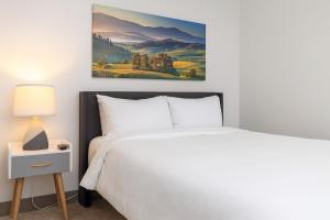 a bedroom with a bed and a painting on the wall at Modern 2BR Gem Rooftop Pool and Workspaces in Birmingham