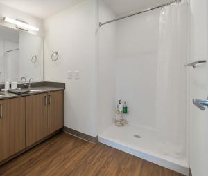 a bathroom with a shower and a sink at Modern 2BR Gem Rooftop Pool and Workspaces in Birmingham