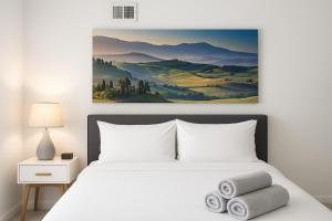 a bedroom with a bed with towels on it at Modern 2BR Gem Rooftop Pool and Workspaces in Birmingham
