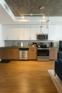 an open kitchen with wooden cabinets and stainless steel appliances at Birmingham Stay 2BR with Rooftop Amenities in Birmingham