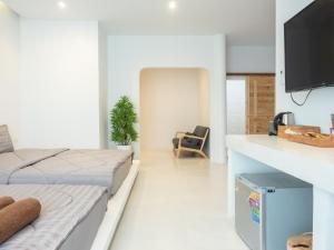 ein weißes Zimmer mit zwei Betten und einem Fernseher in der Unterkunft Fan Sea Resort Kohlarn in Ko Larn