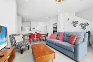 a living room with a blue couch and a table at Direct resort access Balcony Pool Upgraded Inside in Kissimmee