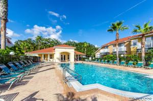 a pool at a resort with chairs and palm trees at Direct resort access Balcony Pool Upgraded Inside in Kissimmee