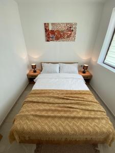 a bedroom with a bed with a blanket on it at Snow Hill Kopaonik in Zrenjanin