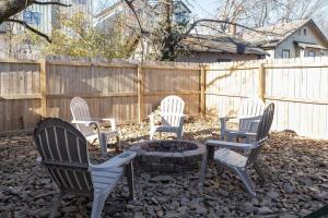 Cuatro sillas alrededor de una fogata en un patio trasero. en Luxury Home next to U of A Dickson St & downtown, en Fayetteville