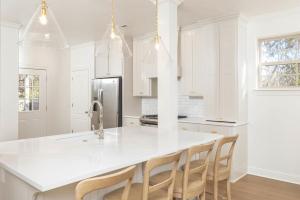 Una cocina con gabinetes blancos y una gran isla blanca. en Luxury Home next to U of A Dickson St & downtown, en Fayetteville