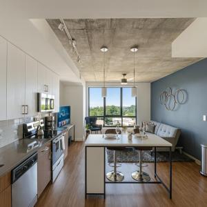 an open kitchen and living room with a large window at Bright 2BR Apt Pool, Gym Walkable Area in Birmingham