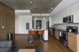 a kitchen with a counter and two bar stools at Bright 2BR Apt Pool, Gym Walkable Area in Birmingham +10 photos