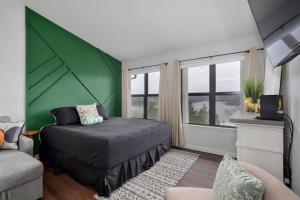 a bedroom with a bed and a green wall at Luxury Studio Condo With Beautiful Lake View in Radical +21 photos