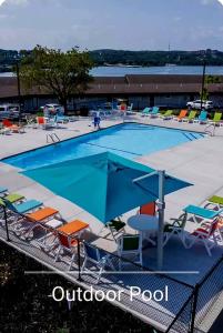 a swimming pool with chairs and an umbrella at Luxury Studio Condo With Beautiful Lake View in Radical