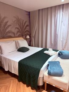 a bedroom with two beds with green and white sheets at Santé Vivre L'expericénce, Búzios in Búzios
