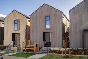 a house with wooden cladding on the side of it at Whetu Luxury Villa Queenstown in Queenstown Airport