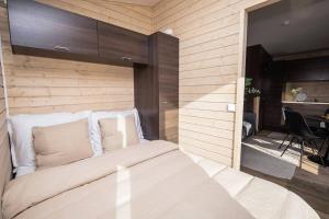 a bedroom with a bed with a wooden wall at Compact Cabin for Remote Work and Adventures in Yllas in Ylläsjärvi