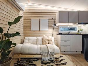 a living room with a white couch and a kitchen at Compact Cabin for Remote Work and Adventures in Yllas in Ylläsjärvi