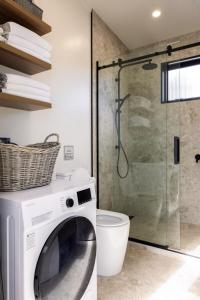 a washing machine in a bathroom with a shower at The Alpine 2-Bedroom Villa - Roam Lake Tekapo in Lake Tekapo +37 photos