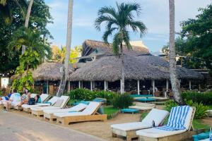 a group of lounge chairs in front of a resort at Bonita Beach Villa in La Ceiba