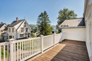 Arctic Hilltop Lodge - Historic Swiss-style Home في Guleng: سطح خشبي مع سياج أبيض ومرآب