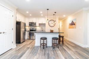 cocina con armarios blancos y barra con taburetes en 1BR 20E - Cozy Downtown Atlanta Condo, en Atlanta