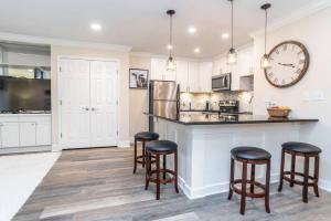 Una cocina con gabinetes blancos y taburetes de bar. en 1BR 20E - Cozy Downtown Atlanta Condo, en Atlanta