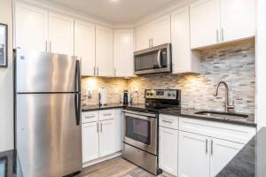 Una cocina con gabinetes blancos y un refrigerador de acero inoxidable. en 1BR 20E - Cozy Downtown Atlanta Condo, en Atlanta