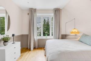 Arctic Hilltop Lodge - Historic Swiss-style Home في Guleng: غرفة نوم بيضاء مع سرير ونافذة