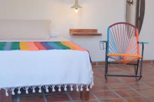 a bedroom with a bed and a chair at Sayulita beach-side studio 2 by CasasTropical in Sayulita