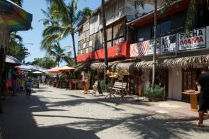 a street in a resort town with shops and palm trees at Sayulita beach-side studio 2 by CasasTropical in Sayulita