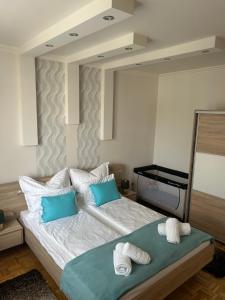 a bedroom with a bed with two towels on it at László Apartman in Debrecen