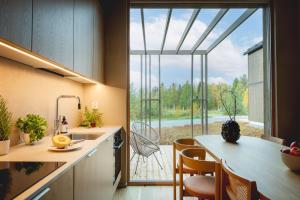 a kitchen with a large window looking out at a patio at Stay North - Joiku - Kajo in Äkäslompolo