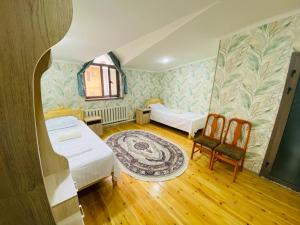 una habitación con dos camas y una mesa y sillas en Villa Yahia hotel str Chashma Ayub 4, en Bukhara 16 fotos más