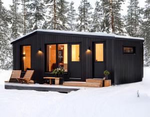 a black tiny house in the snow at Yllas Forest Cabin for Nature Stay in Ylläsjärvi