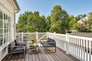 a porch with two chairs and a table on a white fence at Arctic hilltop lodge - Room 3 in Guleng